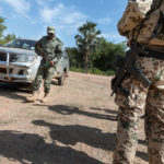 Ein Soldat der malischen Armee während des Trainings zur Umkreissuche nach IEDs. Ausbilder der Bundeswehr kontrollieren das Training.