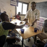 Nach ihrer mühsamen Rückreise aus Nordafrika fanden sechs Migranten in der Hilfsorganisation "AME" Zuflucht. Am Morgen nach ihrer Ankunft bekommen die Migranten vom AME-Mitarbeiter Bassekou Siby ein Frühstück.